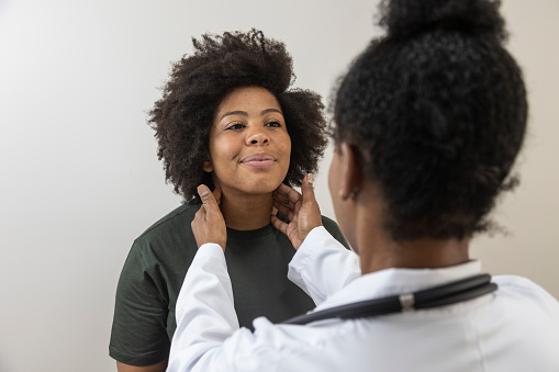 A doctor examining a patient's lymph nodes
