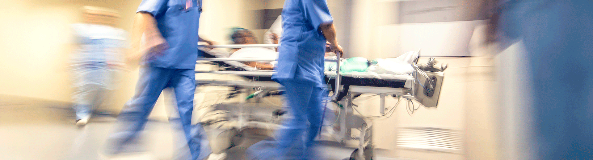 Clinical staff rushing a medical bed through hall - Stroke Outcomes