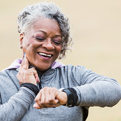 Woman wearing gray checking her heart rate