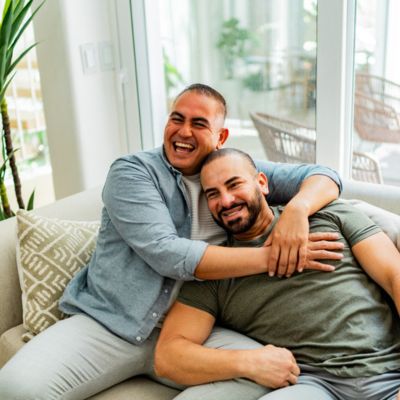 Two Men hugging on a couch