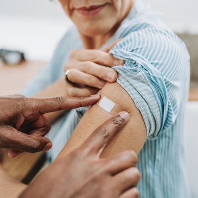 Older woman getting a bandaid on her arm
