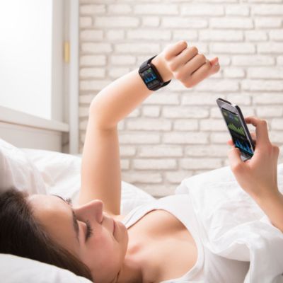 Woman reading her phone and watch tracker