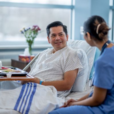Patient in bed talking to clinical staff