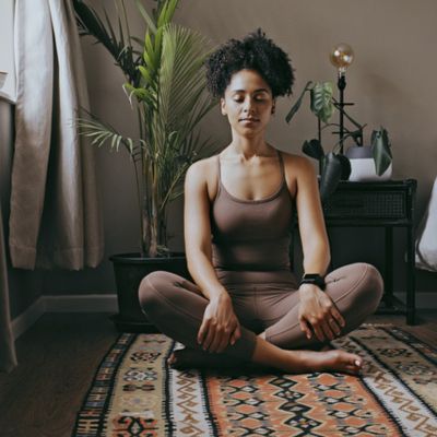 Woman doing meditation on her bedroom floor
