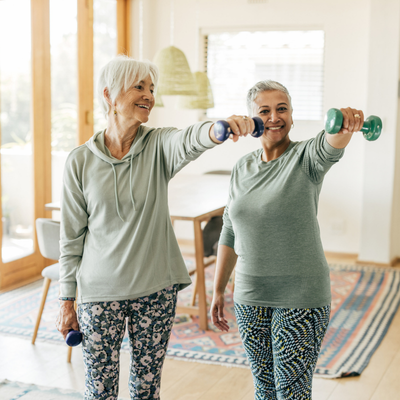 Two mature women practicing resistance training at home