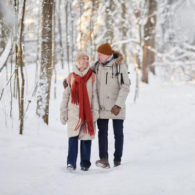 happy older couple walking in snow