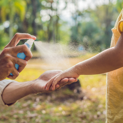Dad and son use mosquito spray
