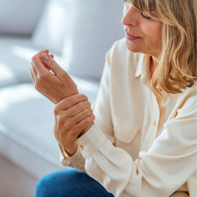 Senior woman suffering from pain in hand at home
