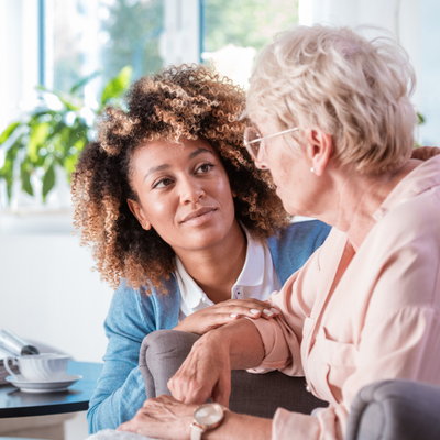 young adult woman caring for elder woman patient