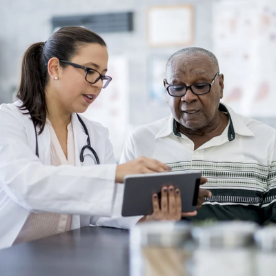 older man with doctor looking at results on a tablet