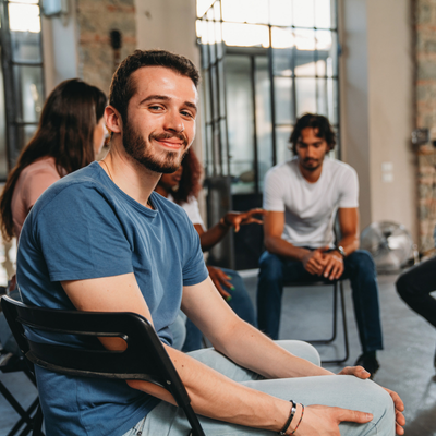 Portrait of a man looking at camera during a group therapy session
