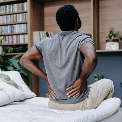A man with back pain sitting on his bed