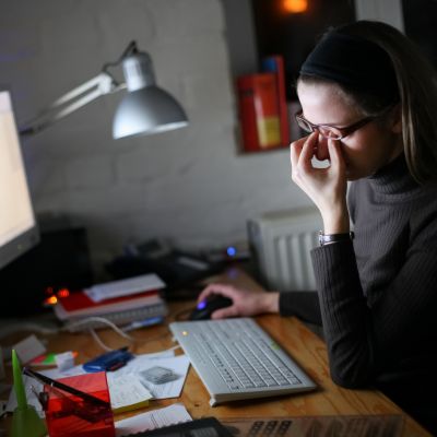 A woman sitting in front of a computer looking distressed 