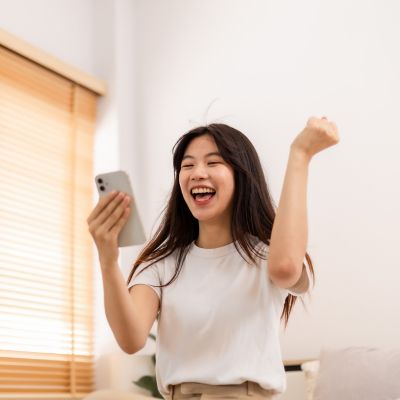 A woman looking at her phone in excitement