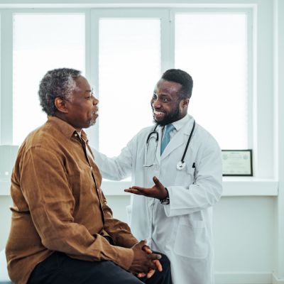 A doctor talking to an older male patient
