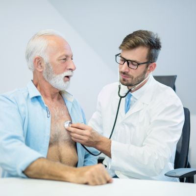 A respiratory therapist listening to his patient's heart