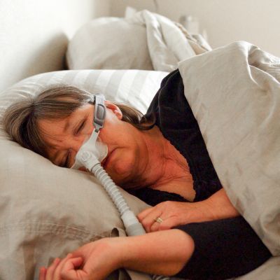 A woman using a CPAP machine while sleeping