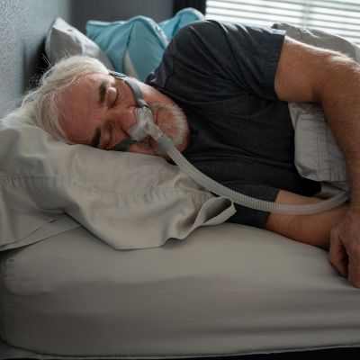 A man using a CPAP machine while sleeping 