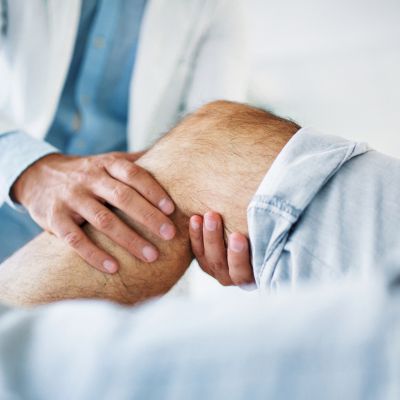 A doctor examining a patient's knee