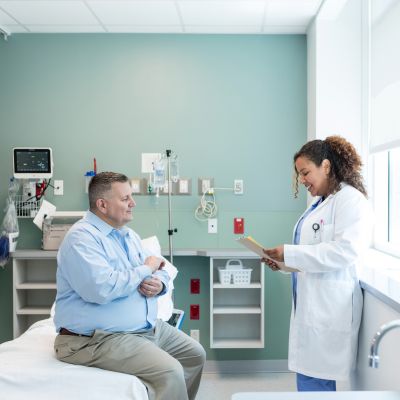 A doctor talking to her patient in an examination room