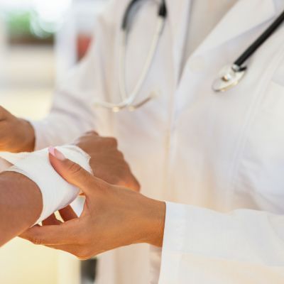 Doctor wrapping a bandage around a patient's wrist