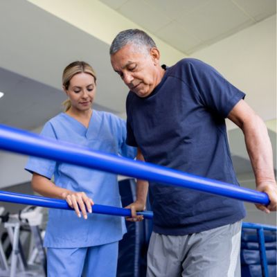 A physical therapist assisting a patient while they're walking