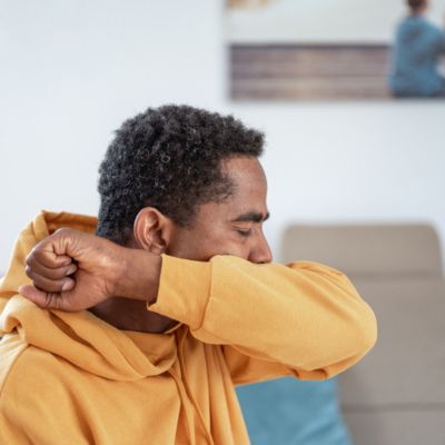 A man coughing into his elbow