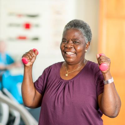 woman holding weights and smiling