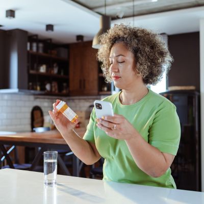 A woman examining a medication bottle