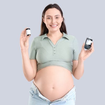 woman holding up a blood sugar testing device for Gestational Diabetes