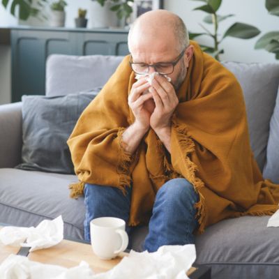 Man sneezing into tissue