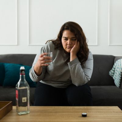 sad heavy set woman with a drink