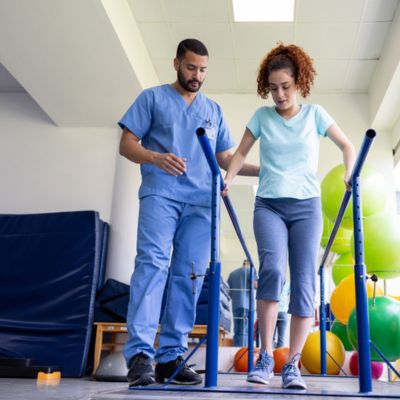 An occupational therapist assisting a patient walking