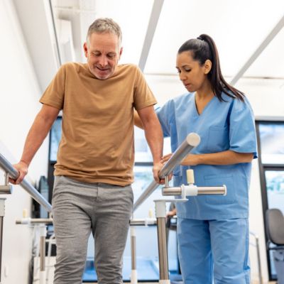 A physical therapist assisting a patient while they're walking
