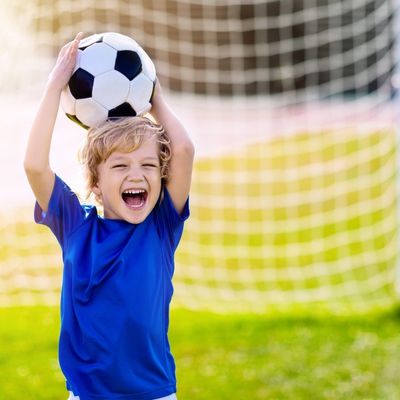 child smiling with soccer ball