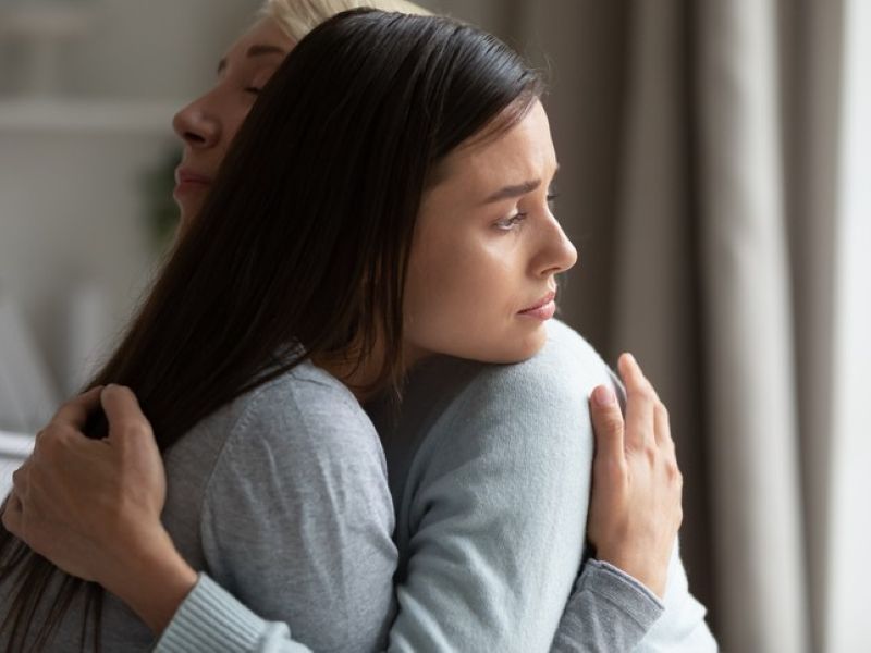 Woman hugging sad girl