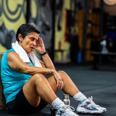 Exhausted woman sitting down after workout