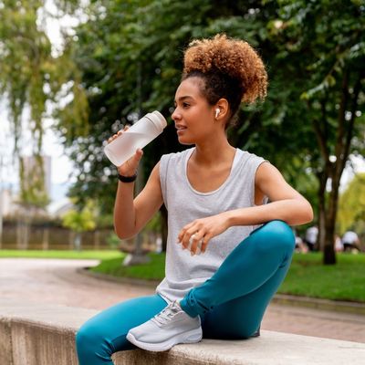 Woman sitting outside drinking water