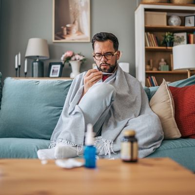 Sick man taking temperature