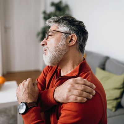Older man holding shoulder in pain