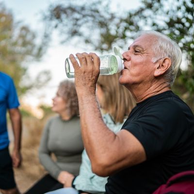Older man drinking water on a hike