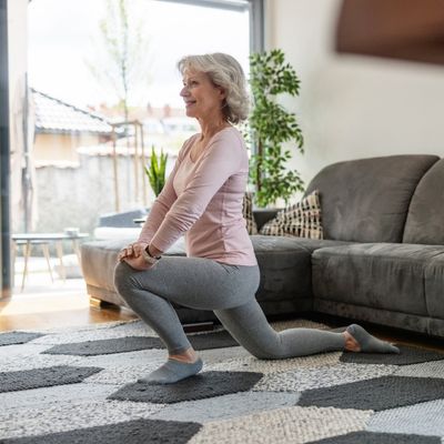 Older woman stretching in living room