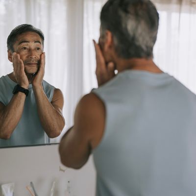 Man looking at face in mirror