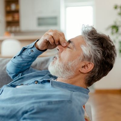 Man pinching bridge of nose in pain