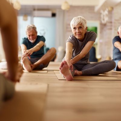 Woman stretching leg in group exercise class