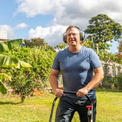 Man mowing lawn with headphones on