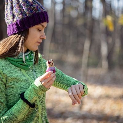 Woman eating granola bar while walking outside