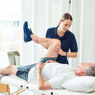 Physical therapist stretching patients leg
