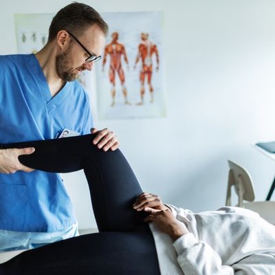 Physical therapist bending patient's knee