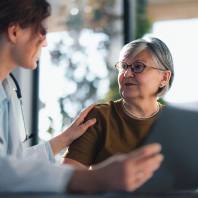 Clinical staff talking to older woman